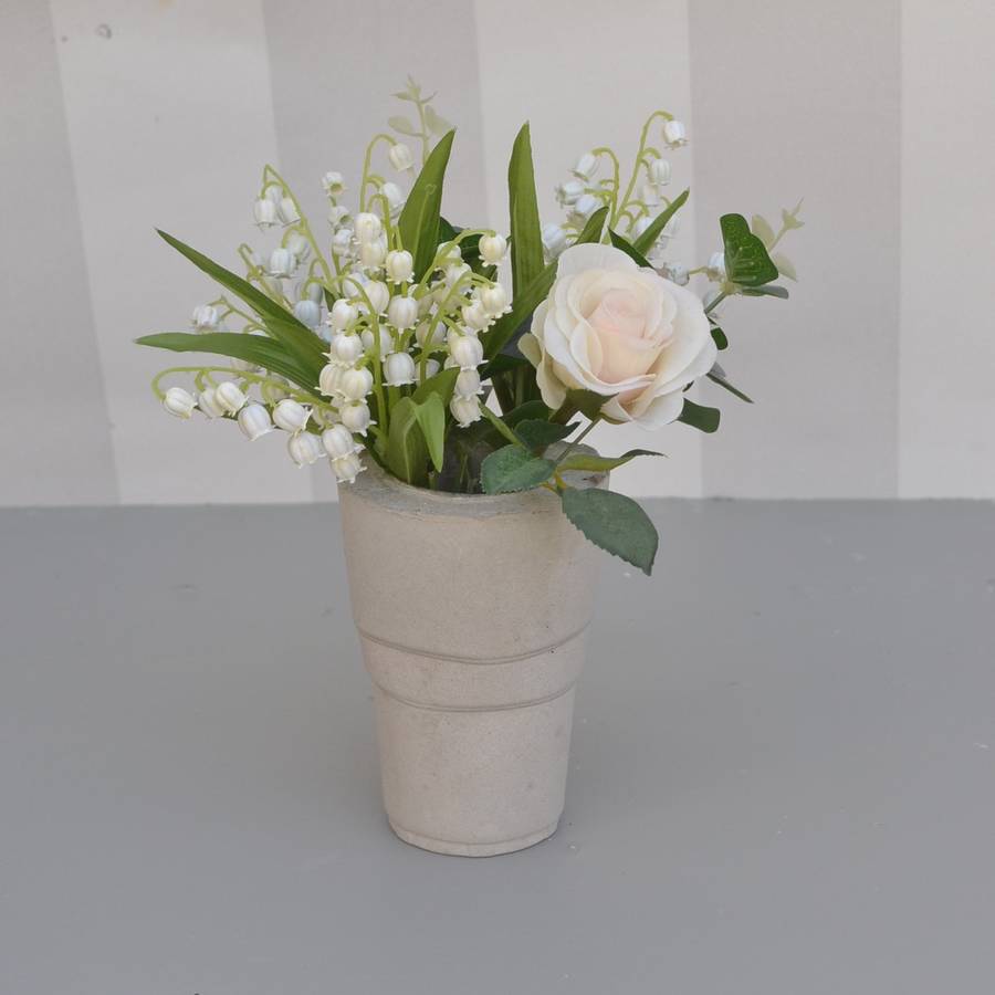 faux lily of the valley bouquet in cement vase by abigail bryans