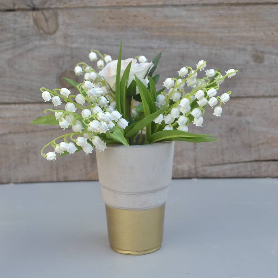 faux lily of the valley bouquet in cement vase by abigail bryans