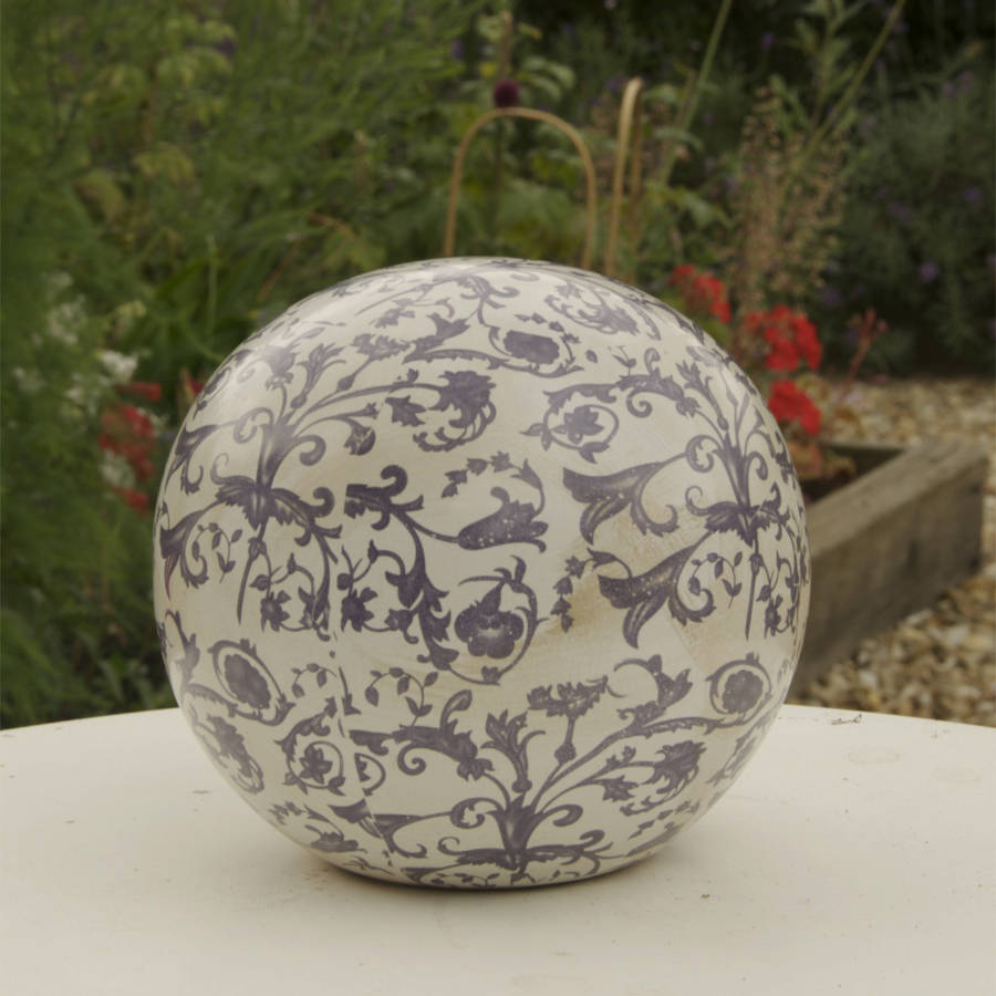 blue and white aged ceramic decorative ball by the orchard