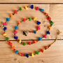 String Of Rainbow Pom Pom's With Brass Bell, thumbnail 1 of 5