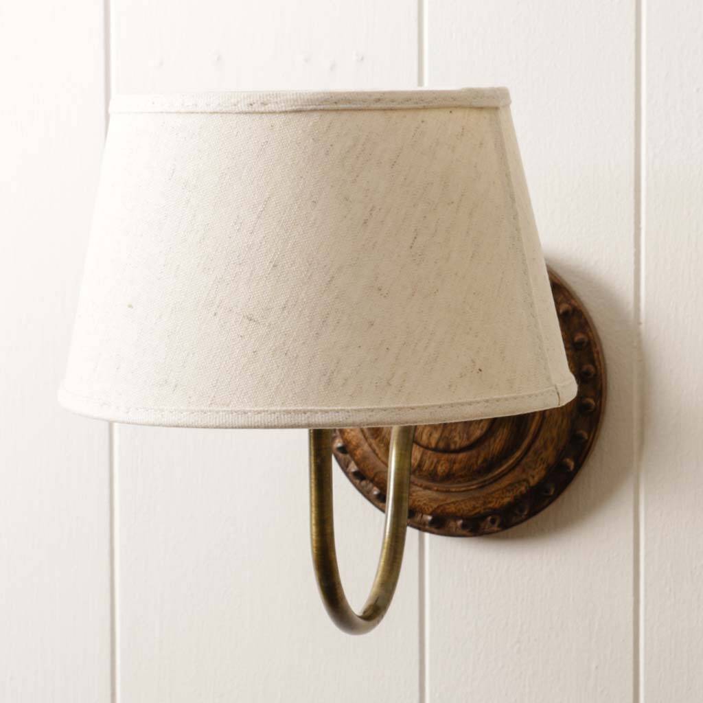carved wooden wall light with linen shade by dibor