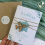 Eucalyptus Floral Sage Green Passport Invitation With Plane Charms For Destination Wedding, thumbnail 1 of 8