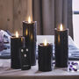 Four Black Dripping Wax Tru Glow Slim LED Pillar Candles, thumbnail 1 of 2