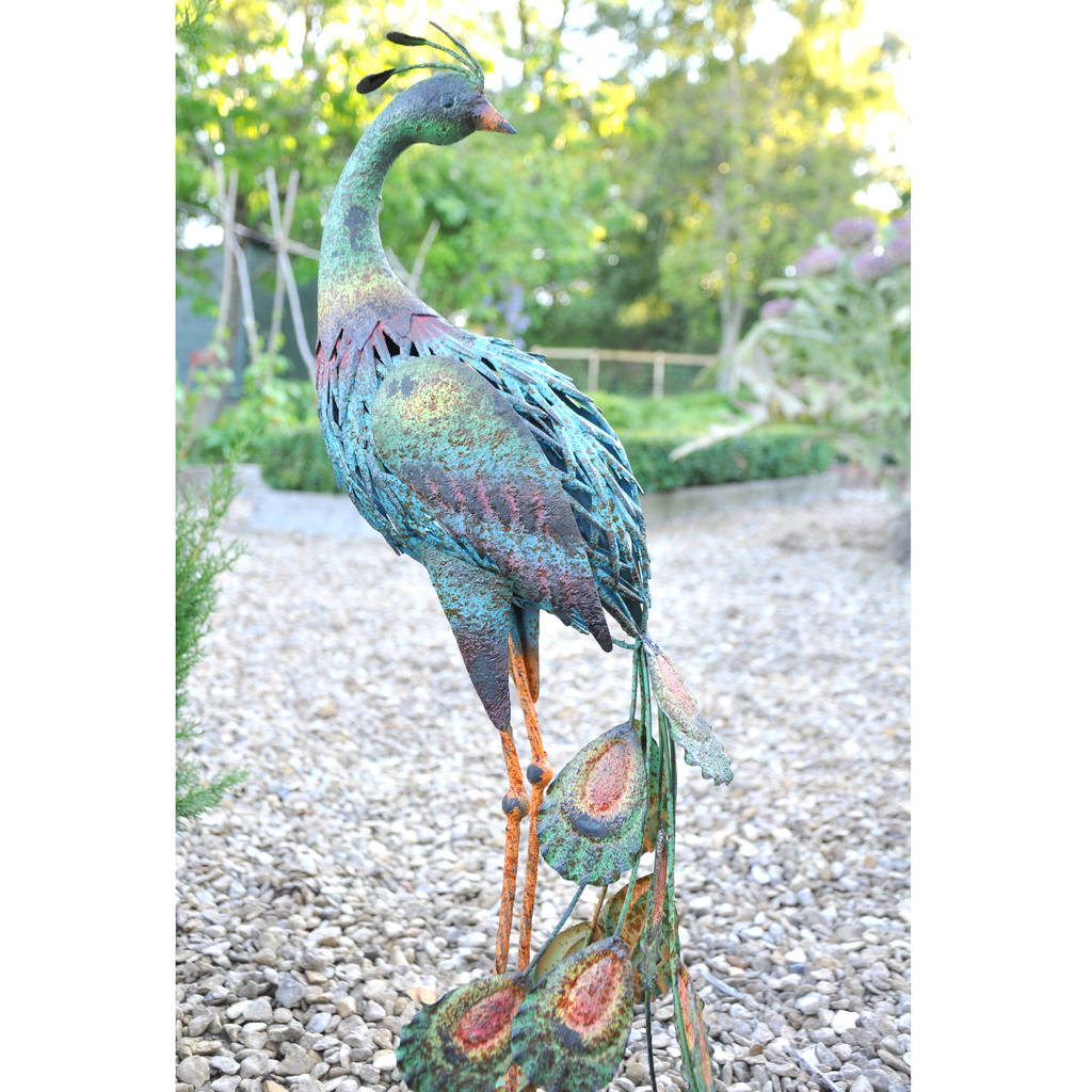 metal garden ornaments hen, goose, flamingo or peacock by the orchard