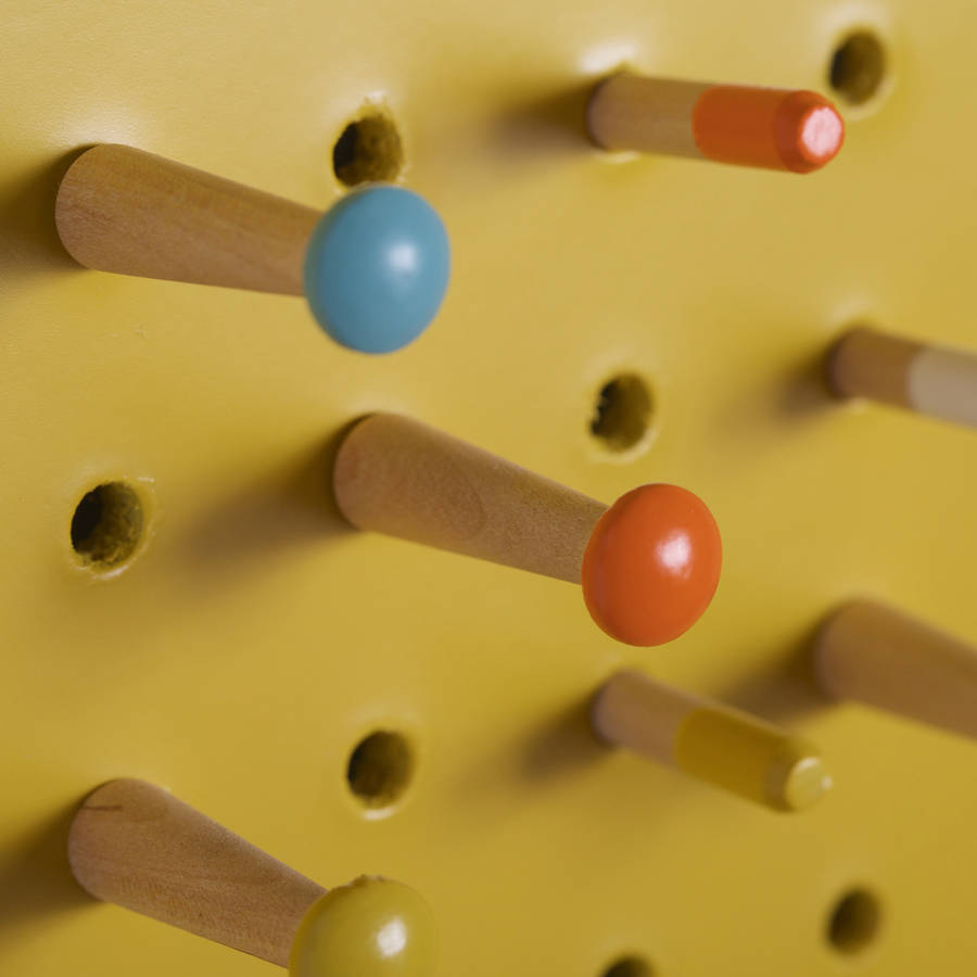 yellow pegboard with wooden pegs, large by block design